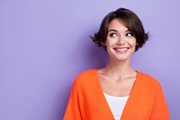Photo of adorable dreamy young woman wear orange cardigan looking empty space isolated violet color...