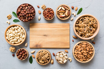 mixed nuts in wooden bowl. Mix of various nuts on colored background. pistachios, cashews, walnuts, hazelnuts, peanuts and brazil nuts