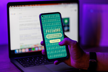 Person typing password on smartphone in laptop background. Digital cybersecurity concept