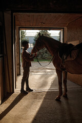 Woman caressing her horse while standing over stable gate