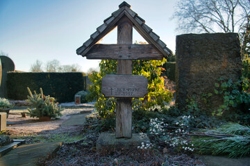 sehr altes Holzkreuz mit Dach  auf einem Friedhof in Ratingen