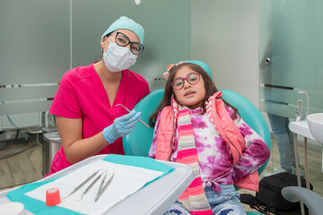 Dentist with mouthpiece and his patient in his office, looking at the camera.