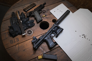 Tactical firearms shooting, pistols, target for shooting with bullet holes and folding knife. - obrazy, fototapety, plakaty