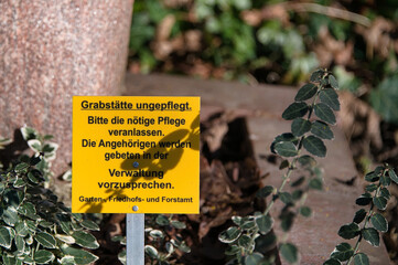 Hinweisschild auf einem Grab, mangelnde Pflege auf einem Friedhof in Düsseldorf