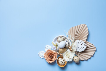 Modern creative composition with easter eggs, palm and monstera leaves and flowers top view. Easter flat lay