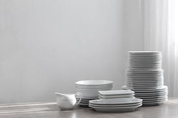 various cutlery on a wooden table against a white wall
