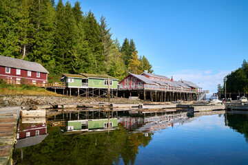 Fototapeta na wymiar Telegraph Cove Historic Building Reflections. The Telegraph Cove marina and accommodations built on pilings surrounding this historic location.