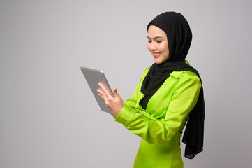 Beautiful musllim woman with hijab using tablet over white background, technology concept. .