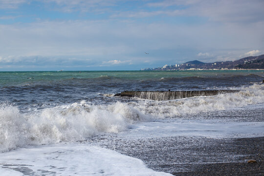 Storm waves with foam on the Black Sea coast. Huge waves under gray skies. Stormy weather