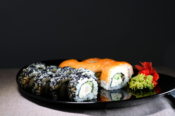 Eating Sushi with chopsticks. Sushi roll japanese food in restaurant. California Sushi roll set with salmon, vegetables, flying fish roe and caviar closeup. Japan restaurant menu. High quality photo