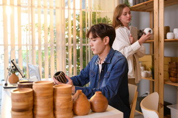 A young couple entrepreneur checking and packaging craft products selling to customers in them shop