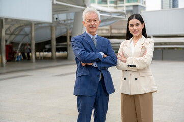 Portrait of Asian senior mature middle aged businessman and young businesswoman in modern city