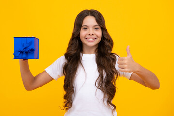 Portrait of teenager child girl 12, 13, 14, years old holding Christmas gift box. Teen giving birthday gift.