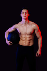 Fototapeta na wymiar Athletic man with fit muscular body training in studio - Active man doing a workout, colorful lighting and background, concepts about fitness, sport and healthy lifestyle