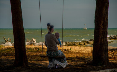 Mother who sits in the swing with the baby