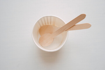 Empty paper cup of ice cream and wood spoon