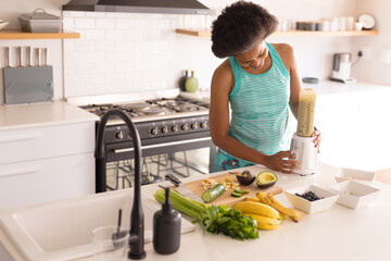 Mid adult african american woman preparing healthy breakfast in kitchen at home