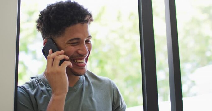 Happy biracial man talking on smartphone and smiling