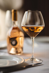 A glass of rose wine on the background of the served table. Sommelier.