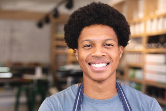 Portrait of smiling young male african american employee with afro hairstyle in coffee shop