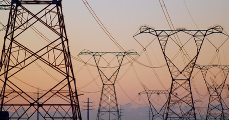 Fototapeta premium Image of electricity poles at sunset