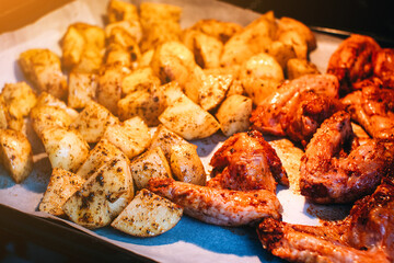 Potato and chicken with spices is baking in electric oven.