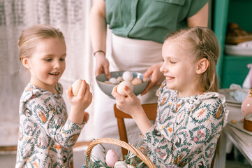 easter holiday time in spring season. happy family candid little kids sisters girls together mother...