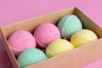 Bath bombs in gift box on pink background closeup. Packaging for gift, sale or delivery