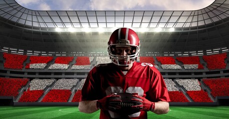 Composite image of male rugby player holding a rugby ball against sports stadium