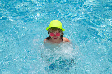 Fototapeta na wymiar Child in swimming pool, healthy outdoor sport activity for children. Kids beach fun. Fashion summer kids in hat and pink sunglasses.