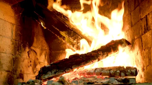 Big Bonfire Burns at Night in Slow Motion. Fire Flames on a Black Background. Fire sparks and flying embers in dark. Large raging campfire of wood. Real campfire from branches burns on nature
