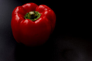 Red pepper on black background. 