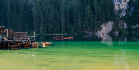 Lake surrounded by the mountains of the Italian alps. Fabulous views, magnificent mountains and lake. Free space for inscription text poster on backdrop nature Lake Braies emerald clear water.