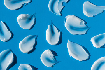 A smears of cream or face mask. The appearance of the texture of the cream on blue background....
