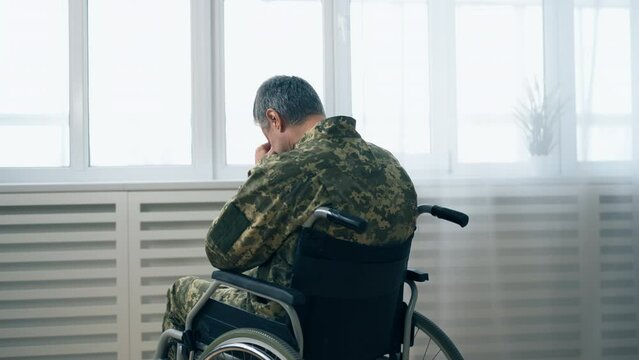 Back view of army veteran with disability crying, difficult times, loneliness