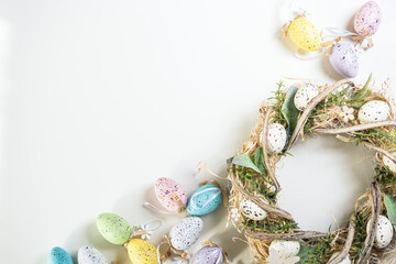 Easter decoration, easter eggs and wreath on white background, close up top view