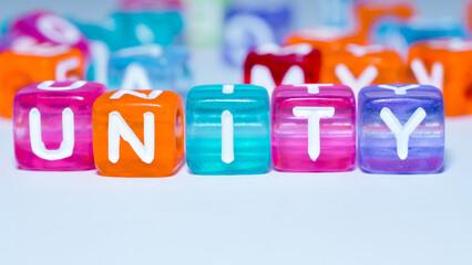 Macro photo of the word "unity" on a colorful cube. fun concept about unity. inscription on the cubes. education sign series for education and learning