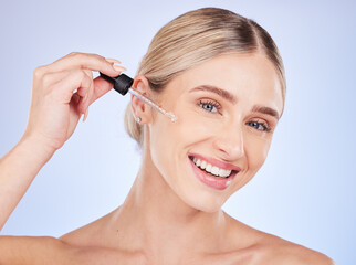 Face, portrait and skincare of woman with serum in studio isolated on a blue background. Dermatology, beauty cosmetics and happy female model apply hyaluronic acid, retinol or essential oil product.