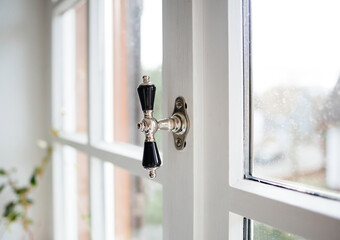 Classic window chrome stone handle on the wooden window - unfocused blur background