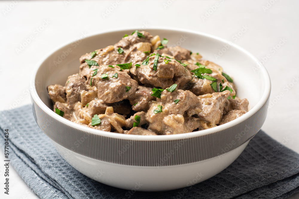 Wall mural Fried chicken liver with creamy sauce in bowl on concrete background