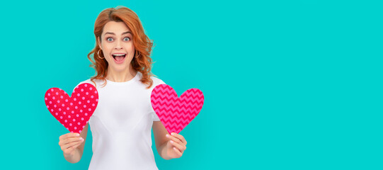happy surprised young girl with red heart on blue background. Woman isolated face portrait, banner with mock up copyspace.
