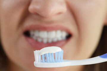 Woman holding tooth brush with snow white toothpaste, morning hygiene