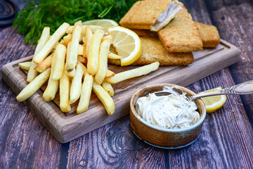   Allasca Pollock Fish  Bites in a crispy Tempura  Batter.Fish and chips .Close up of   crispy breaded  deep fried fish fingers with breadcrumbs s erved with remoulade sauce and  lemon