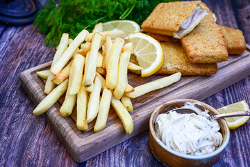   Allasca Pollock Fish  Bites in a crispy Tempura  Batter.Fish and chips .Close up of   crispy breaded  deep fried fish fingers with breadcrumbs s erved with remoulade sauce and  lemon
