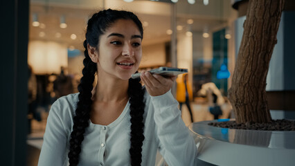 Young arabian woman girl shopper send voice message record audio speech talk on speakerphone activate sound app use ai assistance female businesswoman speak phone cell connection communicating online