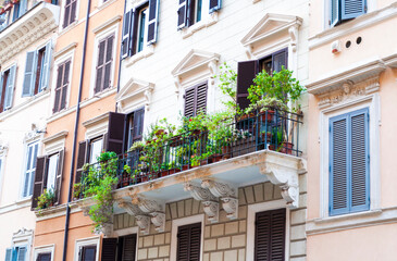 Beautiful balcony with greenery on the facade of an old building in central Rome, Italy.