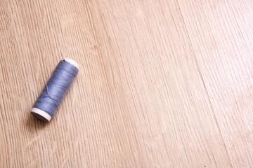 Coil of grey thread on a wooden table