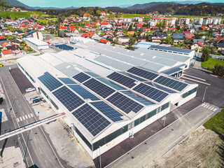 Drone view warehouse in the suburbs with roof top covered in solar panels © VisualProduction