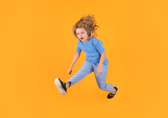 Fototapeta na wymiar Kid boy 8-9 years old in t-shirt jump isolated on yellow background. Childhood lifestyle concept. Mock up copy space. Kid having fun, jumping.