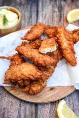 
 Crispy  deep fried   Chicken strips and wedges potato. Breaded  with cornflakes chicken  Breast fillets  with chilly peppers and fresh   basil on wooden rustic background